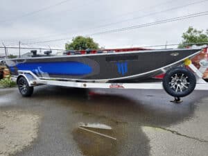 Custom 2025 Willie Power Boat with a blue and black design on a trailer, ready for Kenai River fishing adventures in Alaska.